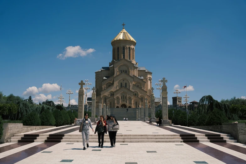 three women and a man walking in front of a building