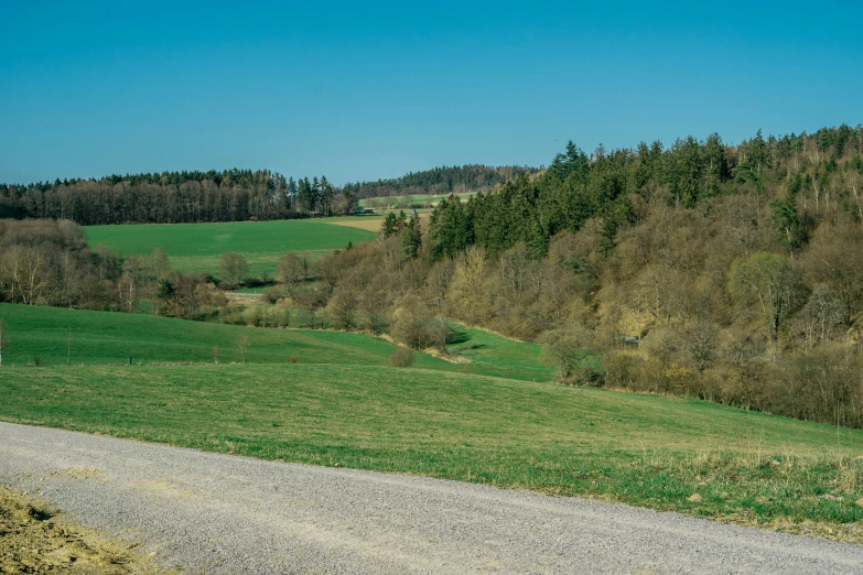 a rural road leading through a green countryside