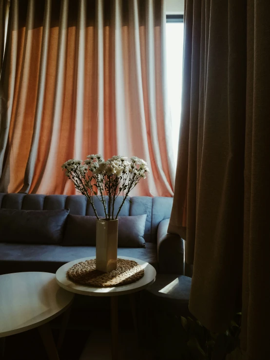 a small table has flowers in a glass vase