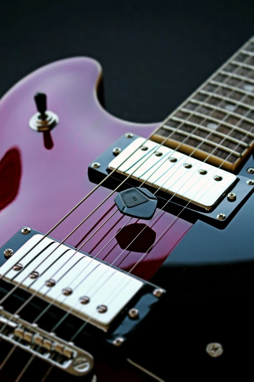 a close up view of the strings on a purple guitar