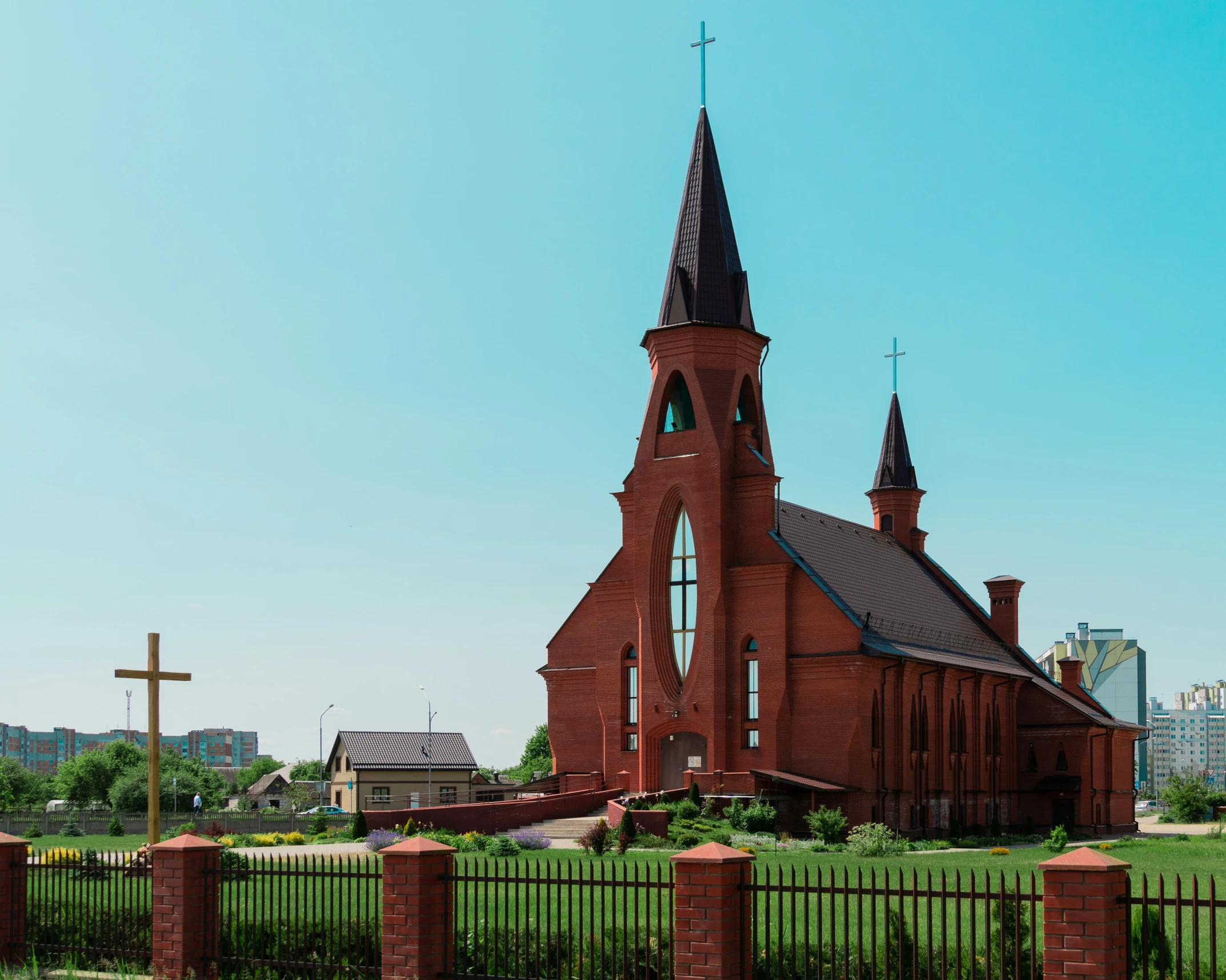 an old church with a steeple is next to a fence