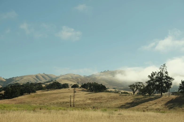 some very pretty hills with some trees and clouds