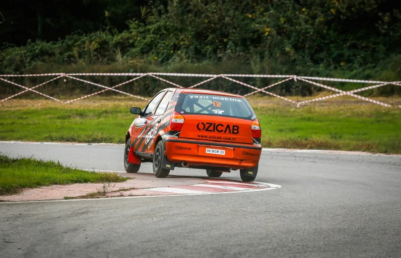 an orange car parked on the side of a track