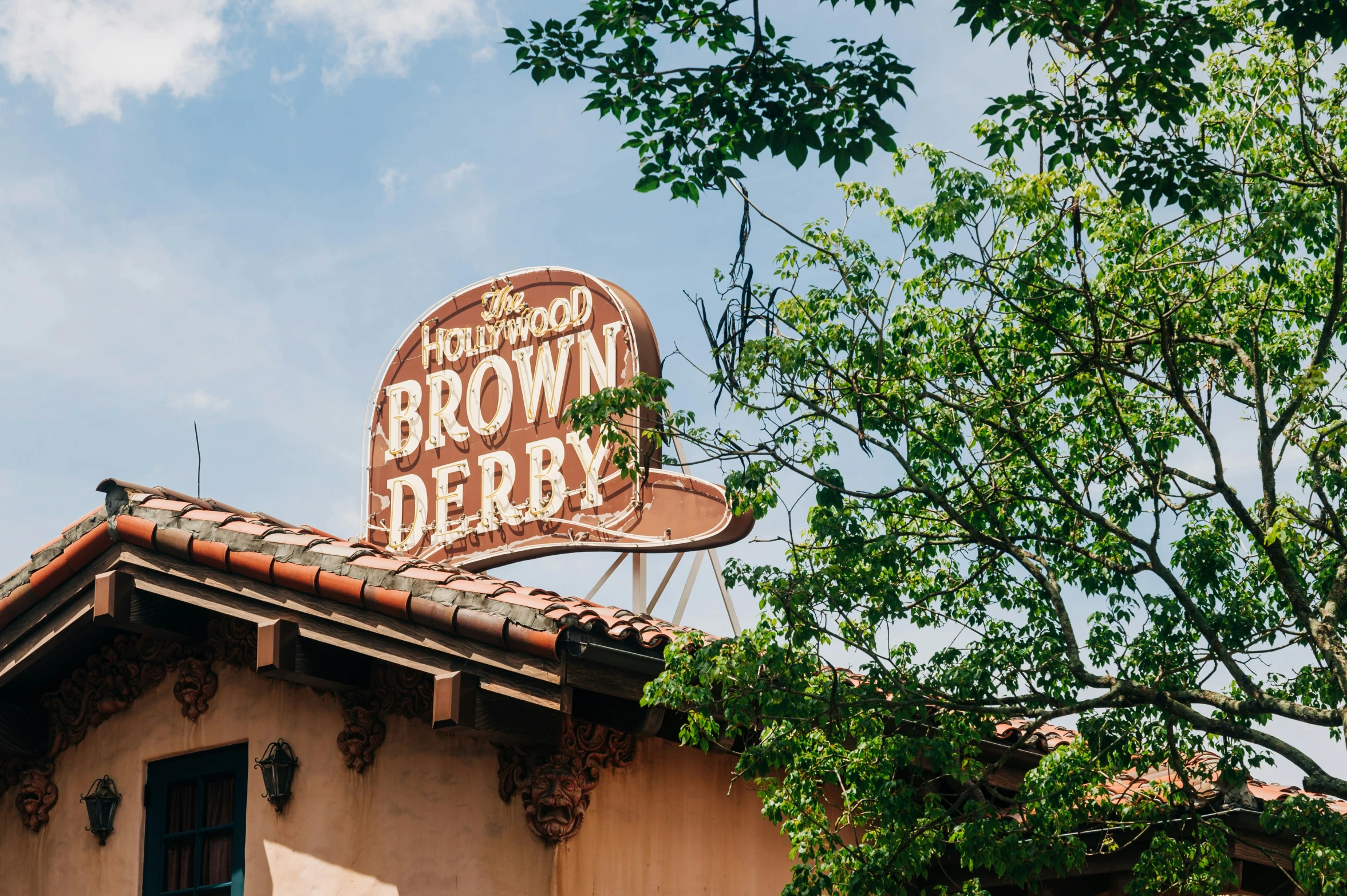 a building is in the shade with a brown sign on top