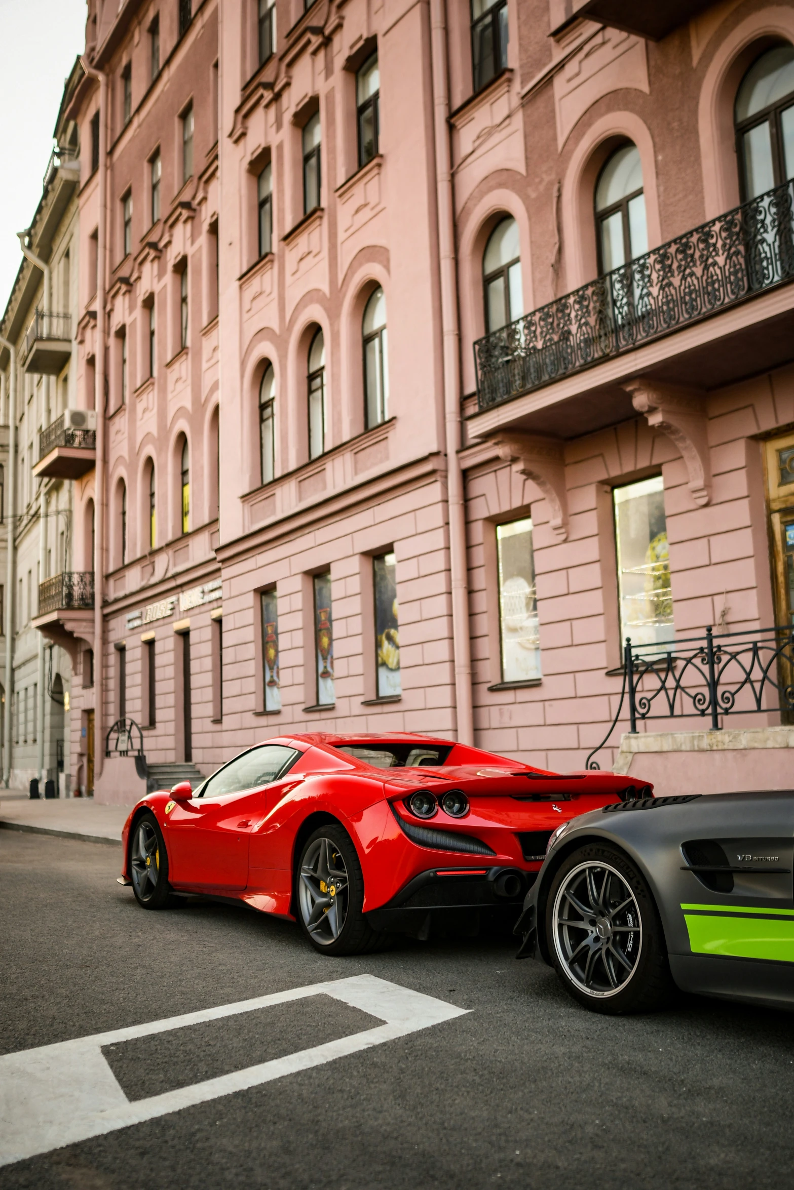 two sports cars in front of large building