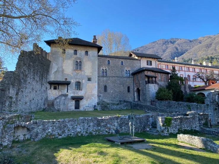 an old stone building with a stone fence in front of it