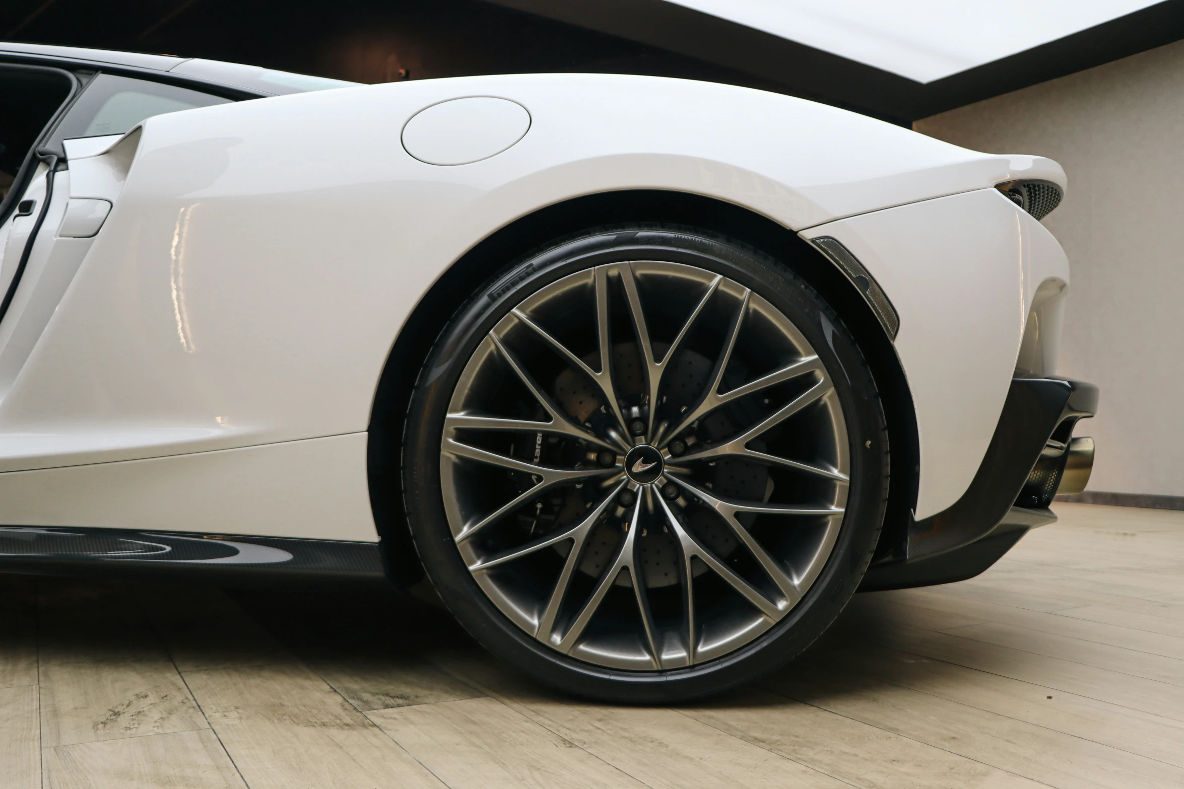 a white sports car with black rims sitting on the ground