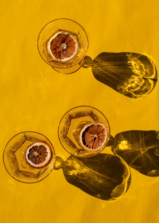 two wine glasses filled with fruit and placed on the table