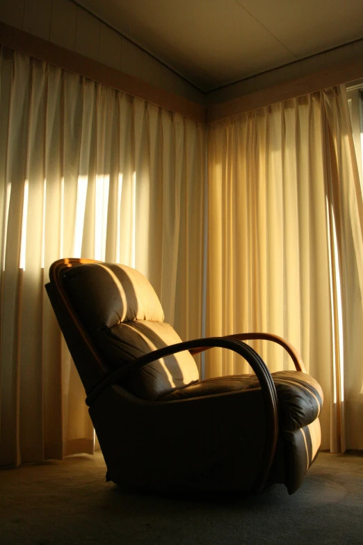 a chair with a pillow in front of a window