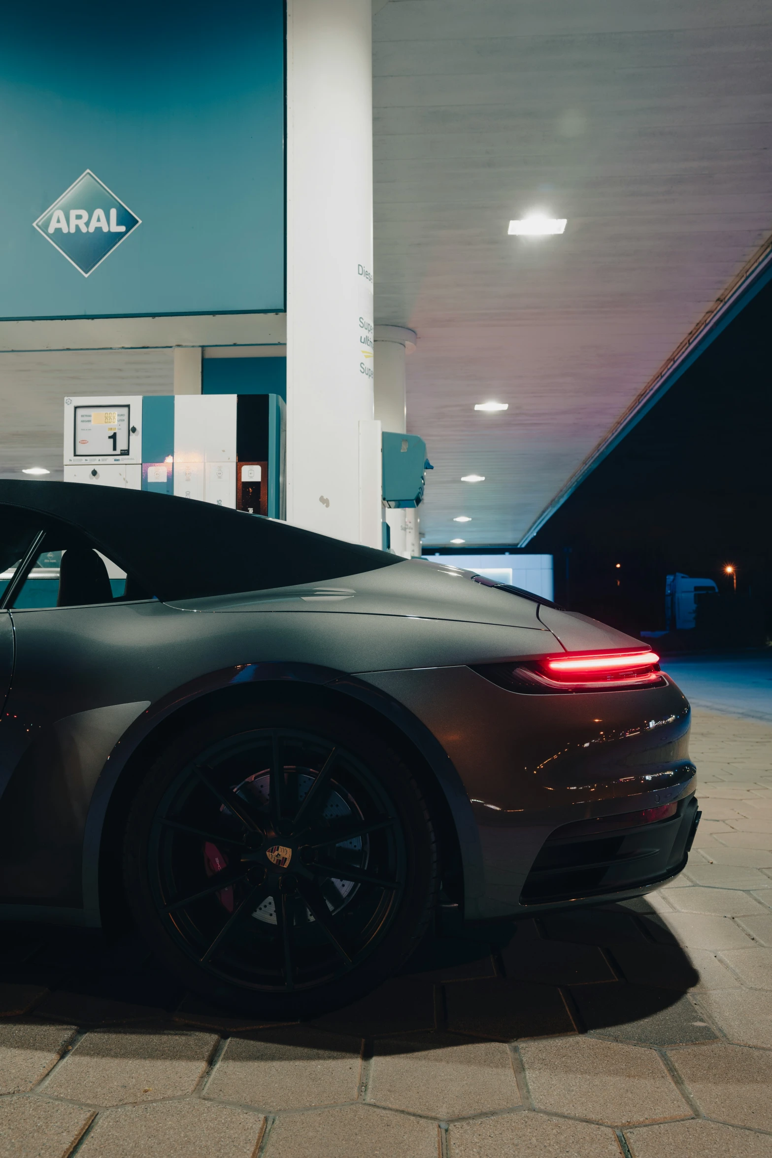 a gray sports car is parked in a parking garage