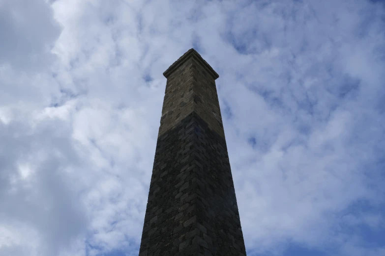 a tall stone tower standing under a cloudy sky
