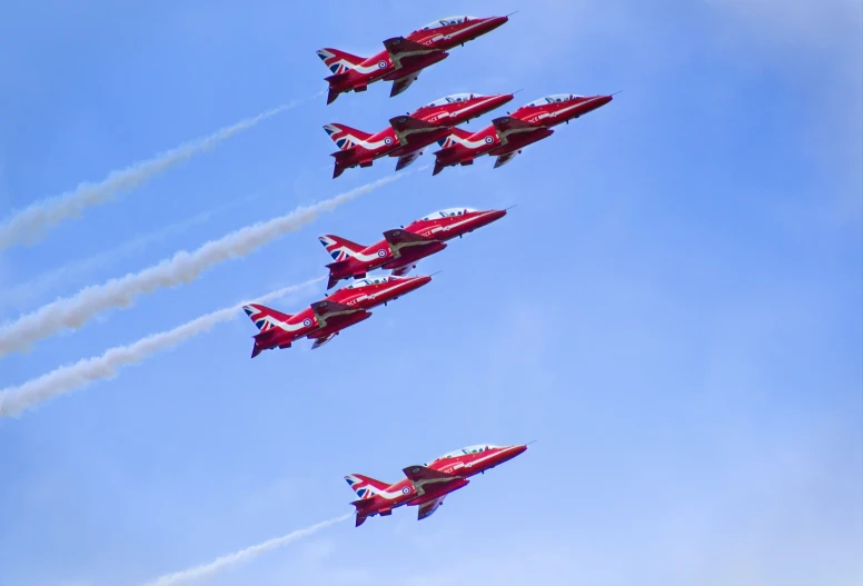 four jets are flying in formation with contrails trailing