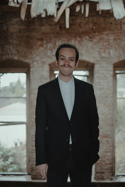 a man is standing near a brick building