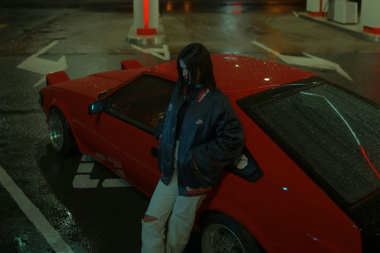 a man is standing next to a red car