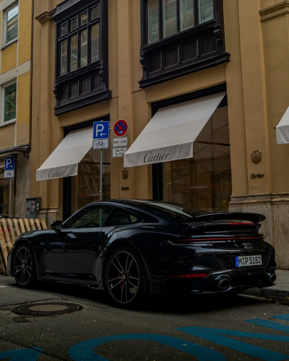 a porsche gt4 is parked in front of a building with awnings