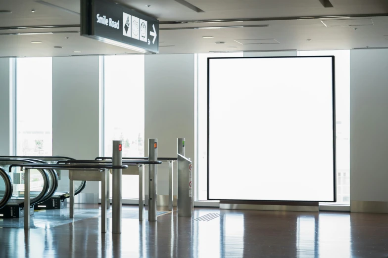 empty tables with umbrellas stand at the entrance to an airport