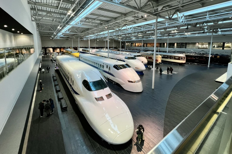 white trains are parked inside a large building