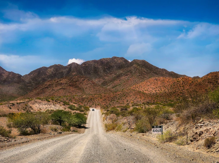 a dirt road is between two mountains on a clear day