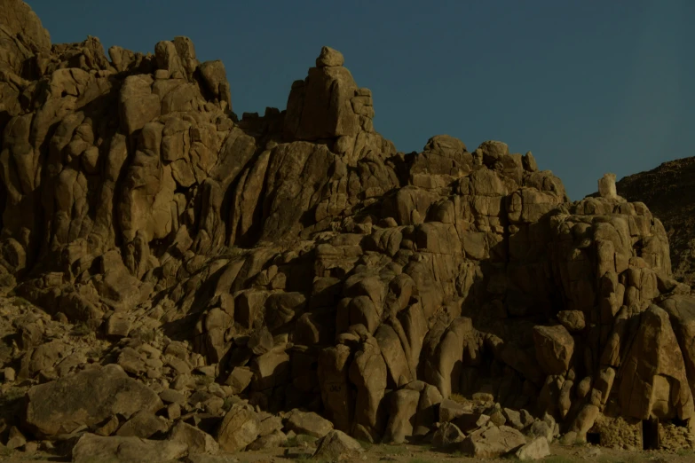 a person is standing near a large rock formation