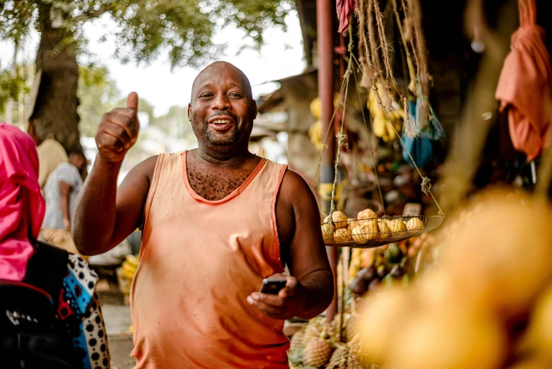 man with a smile on his face at a fruit and vegetable stand