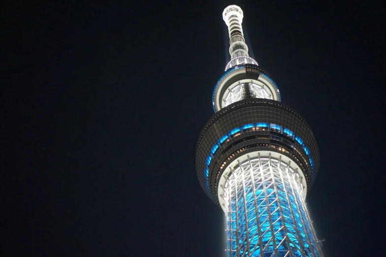 the night view of a large tall tower with lights on