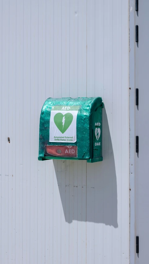 a green mailbox mounted on the side of a building