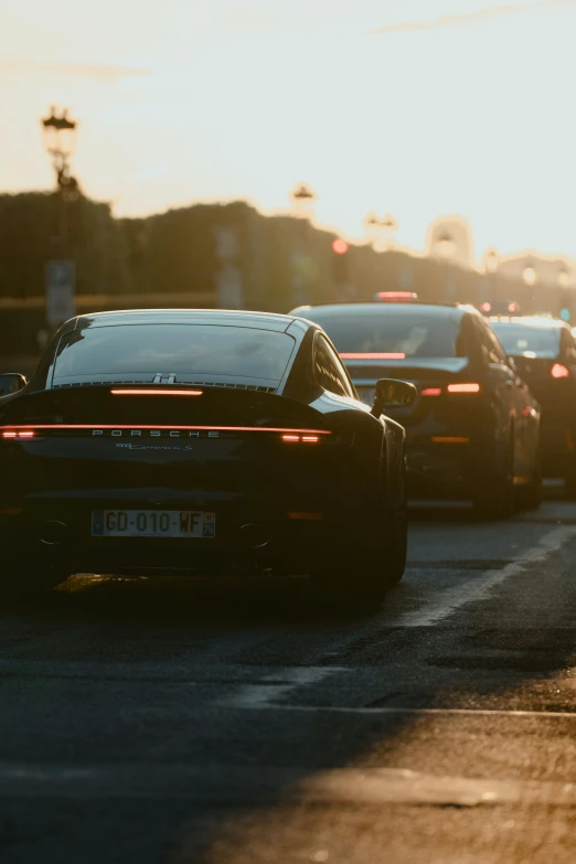 a group of cars driving down a street near tall buildings