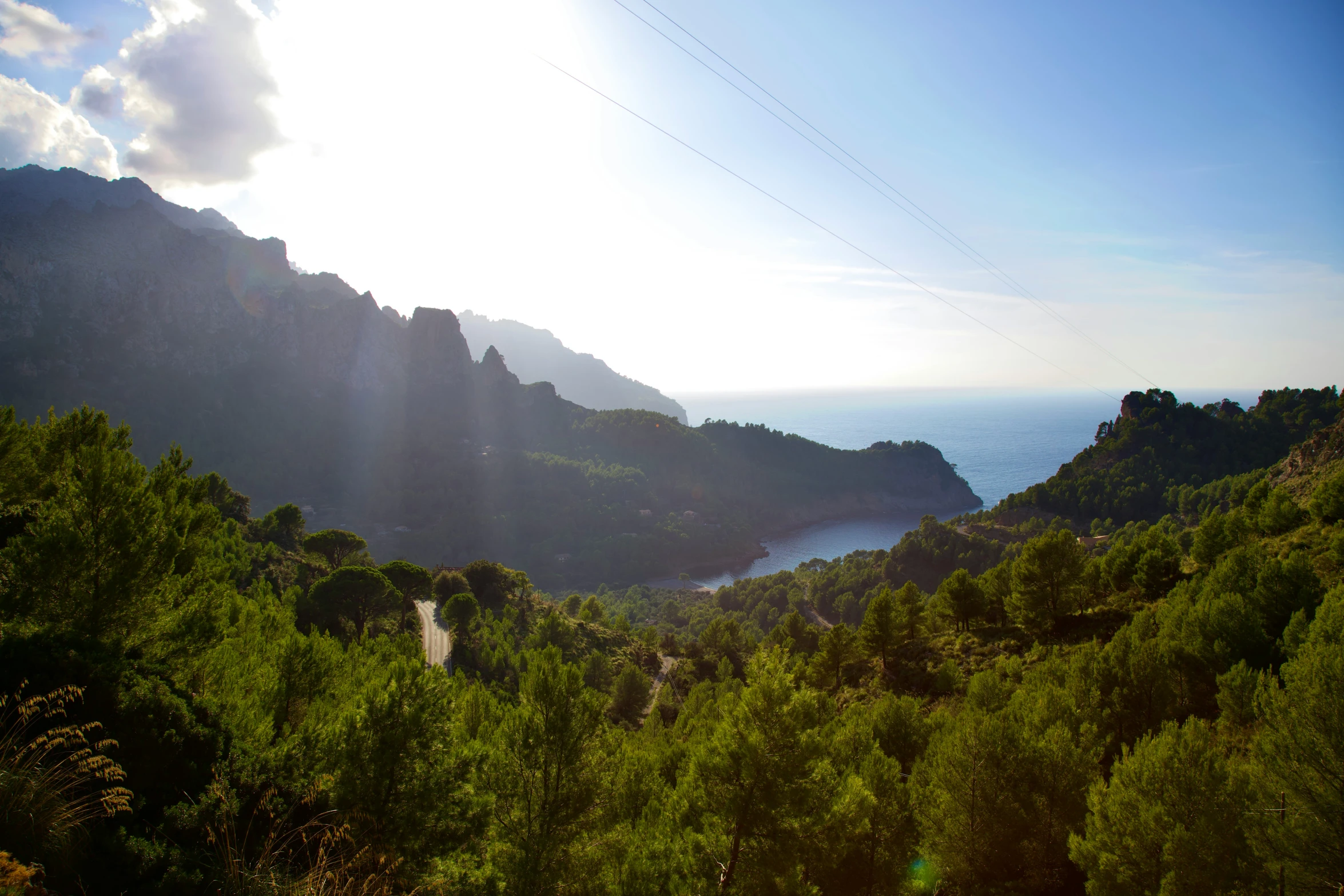 the sun is shining brightly over a mountain top