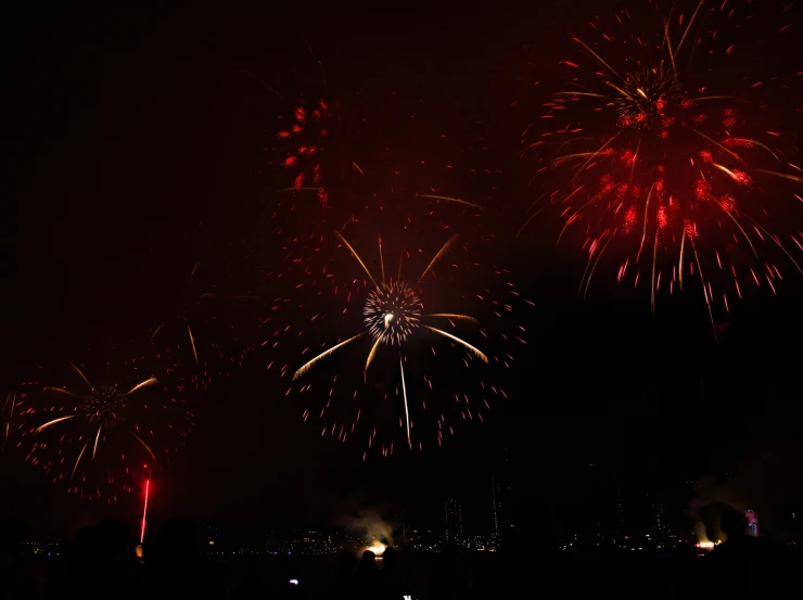 fireworks exploding in the dark sky with red and yellow colors