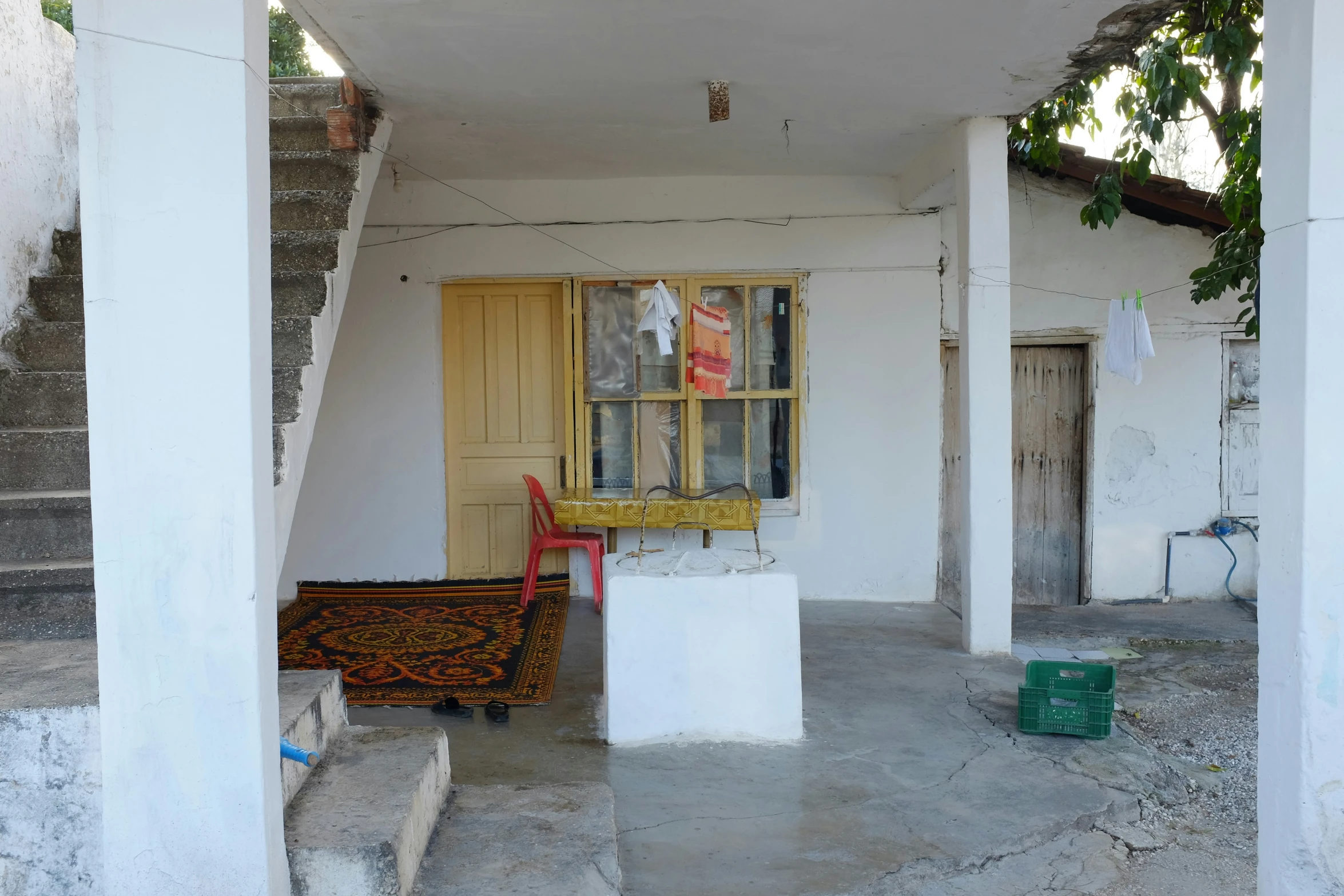 a patio with a table and chairs outside of a house