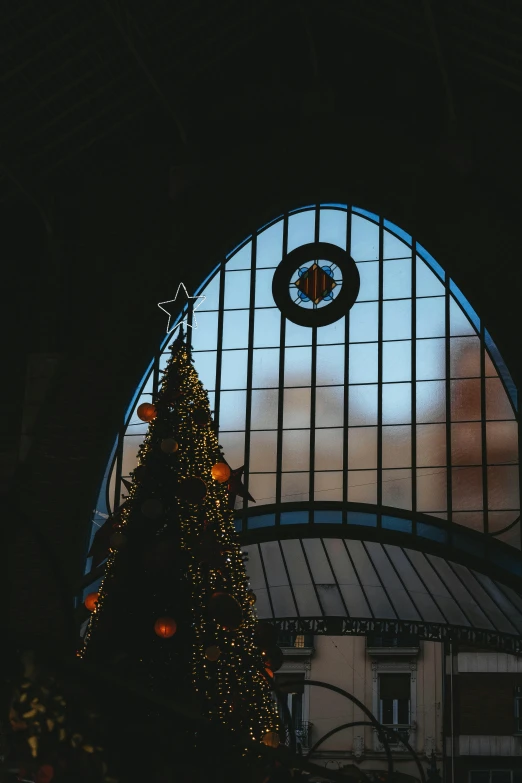 a decorated christmas tree in front of a large window