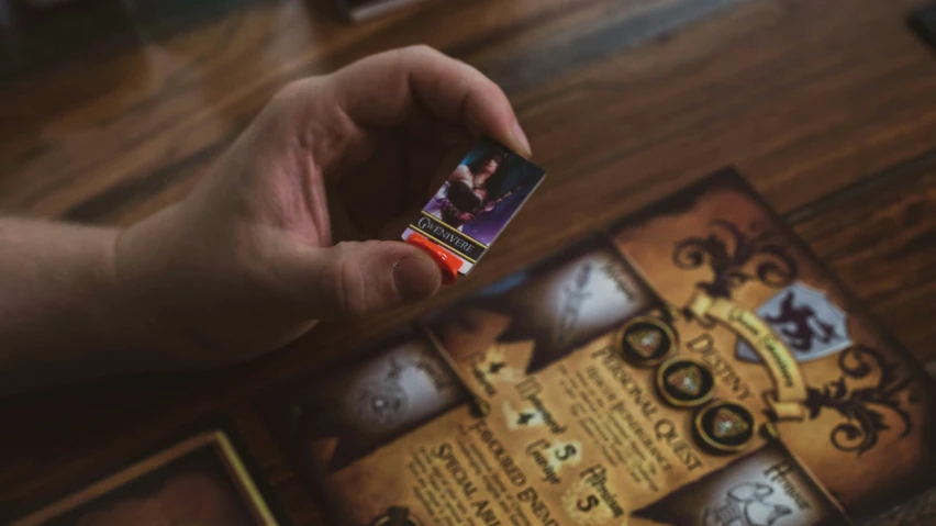 the person is holding a card that has been placed on top of the board