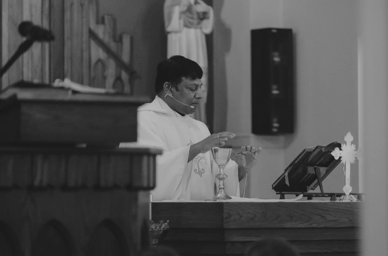 a priest praying at a mass on a pulpit