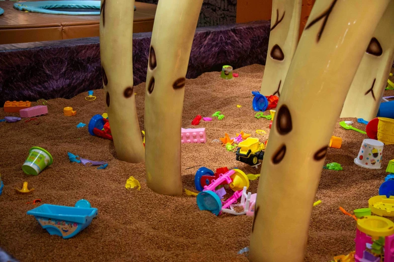 toys and cars scattered around large wooden trees in playroom