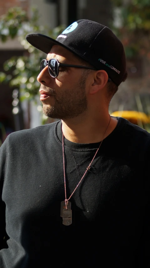 a man with a hat and sunglasses looking away from the camera