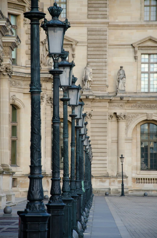 there is a row of street lights in front of a building