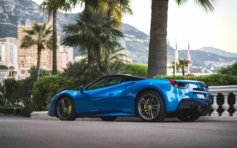 a blue ferrari is parked on the side of the road