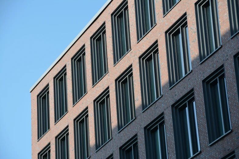 the corner of an apartment building, the top window of a clock, and a sky background