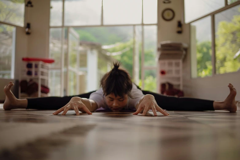 a girl lying down on her side while doing a handstand