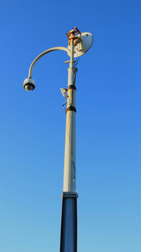 a close up of a street lamp with blue sky in the background