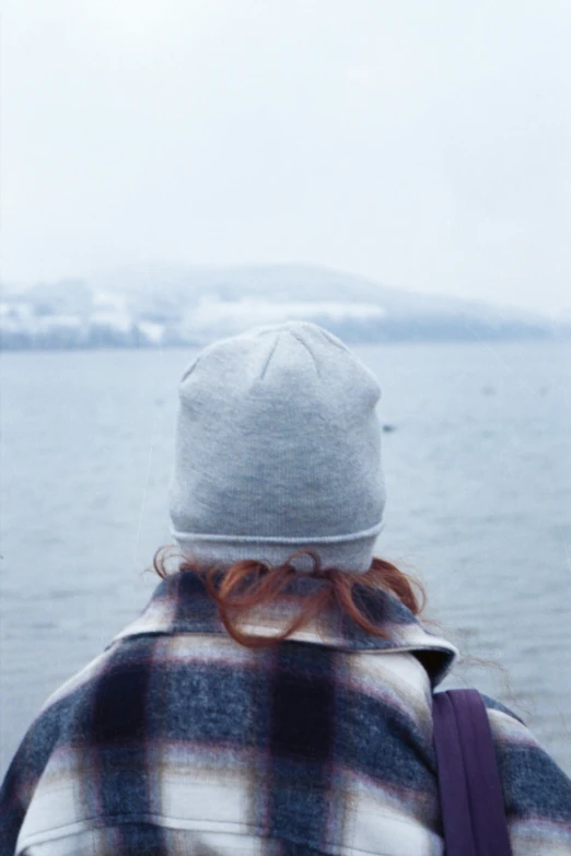 the back view of a young person looking out to sea