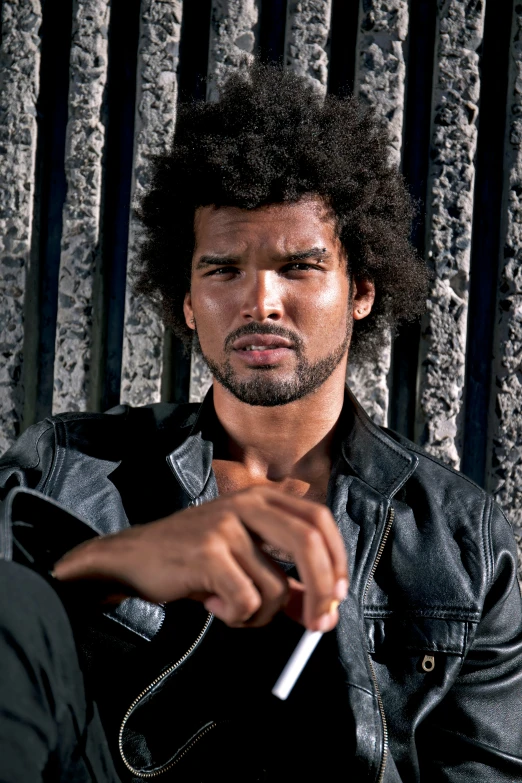 a man smoking a cigarette against a wall