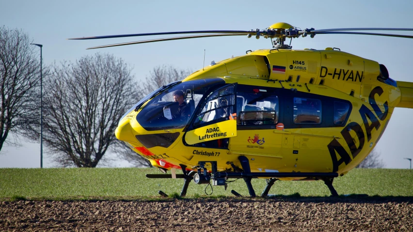 a yellow helicopter that is on the ground