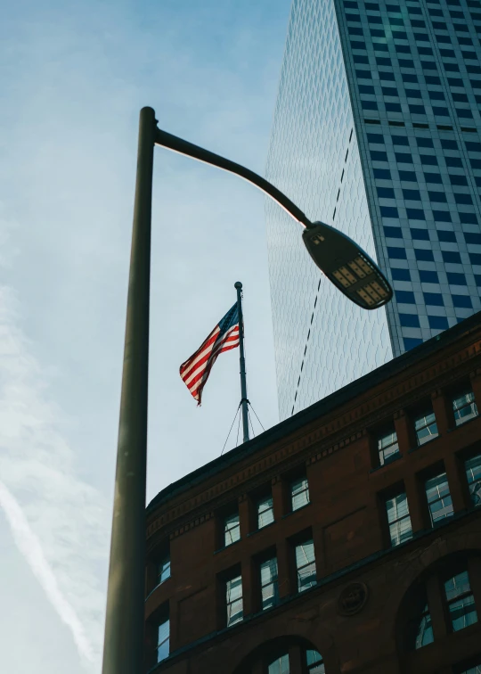 the american flag flying on top of the tall building