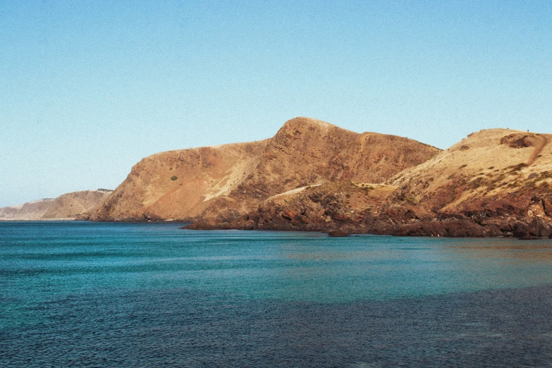 a mountain, water and sky view from the shore