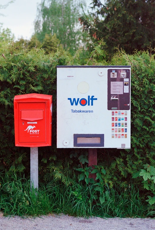 the public pay phone is beside two large red boxes