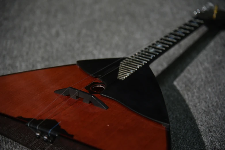 a wooden guitar sitting on a table with a black frisbee resting on it