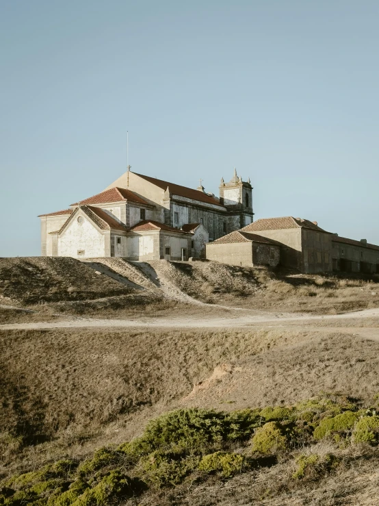 old church and building near dirt road in arid setting