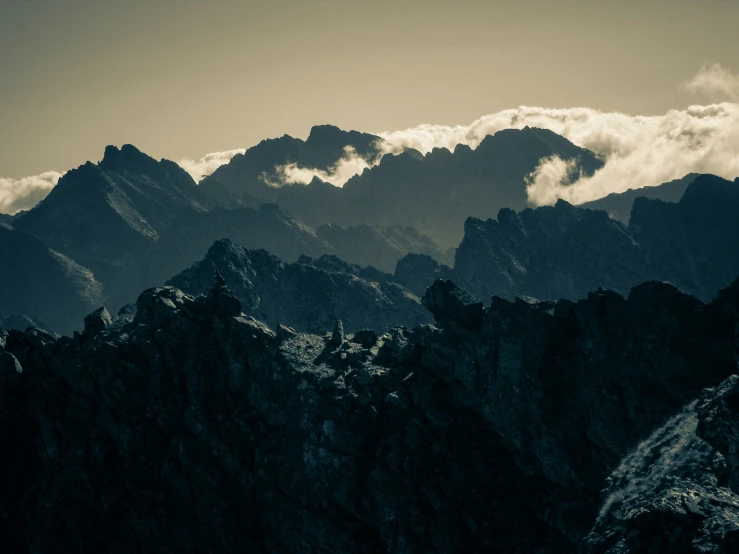 black and white pograph of mountains with clouds in the sky