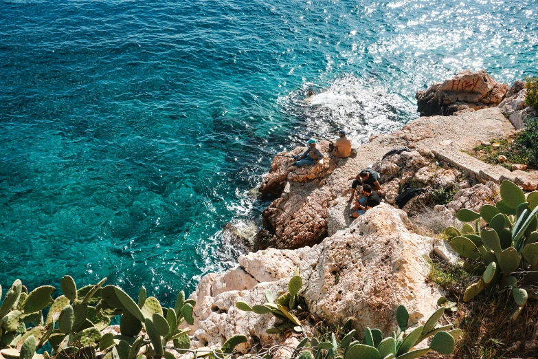 a sea view from above of the rocks and blue water